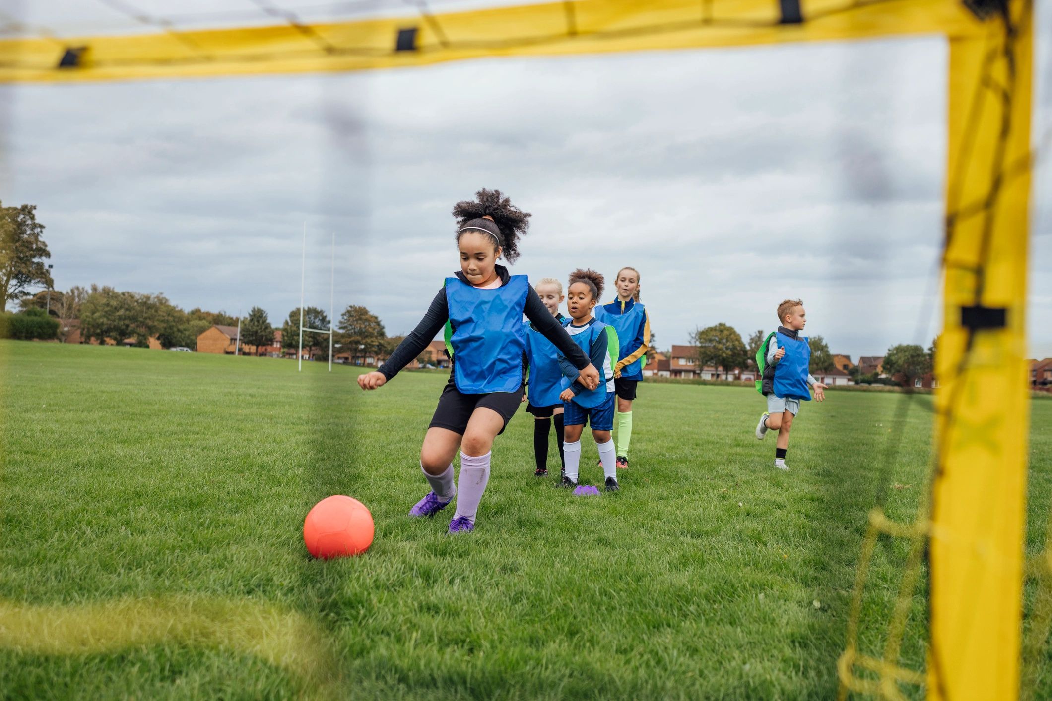 Young soccer players practicing shooting at goal